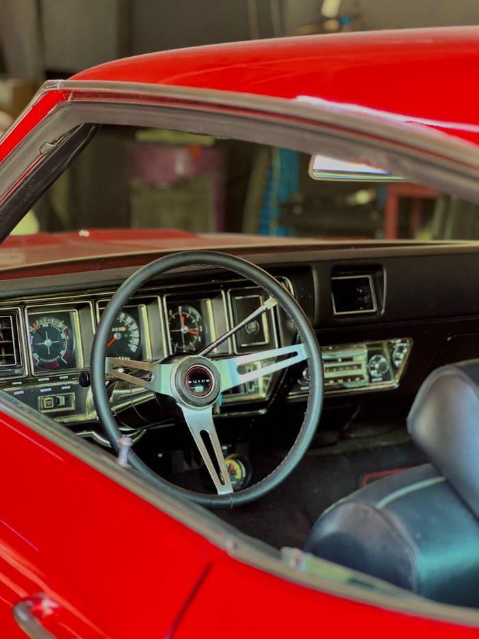 Explore the vintage elegance of a classic car's dashboard and steering in this vibrant photo.